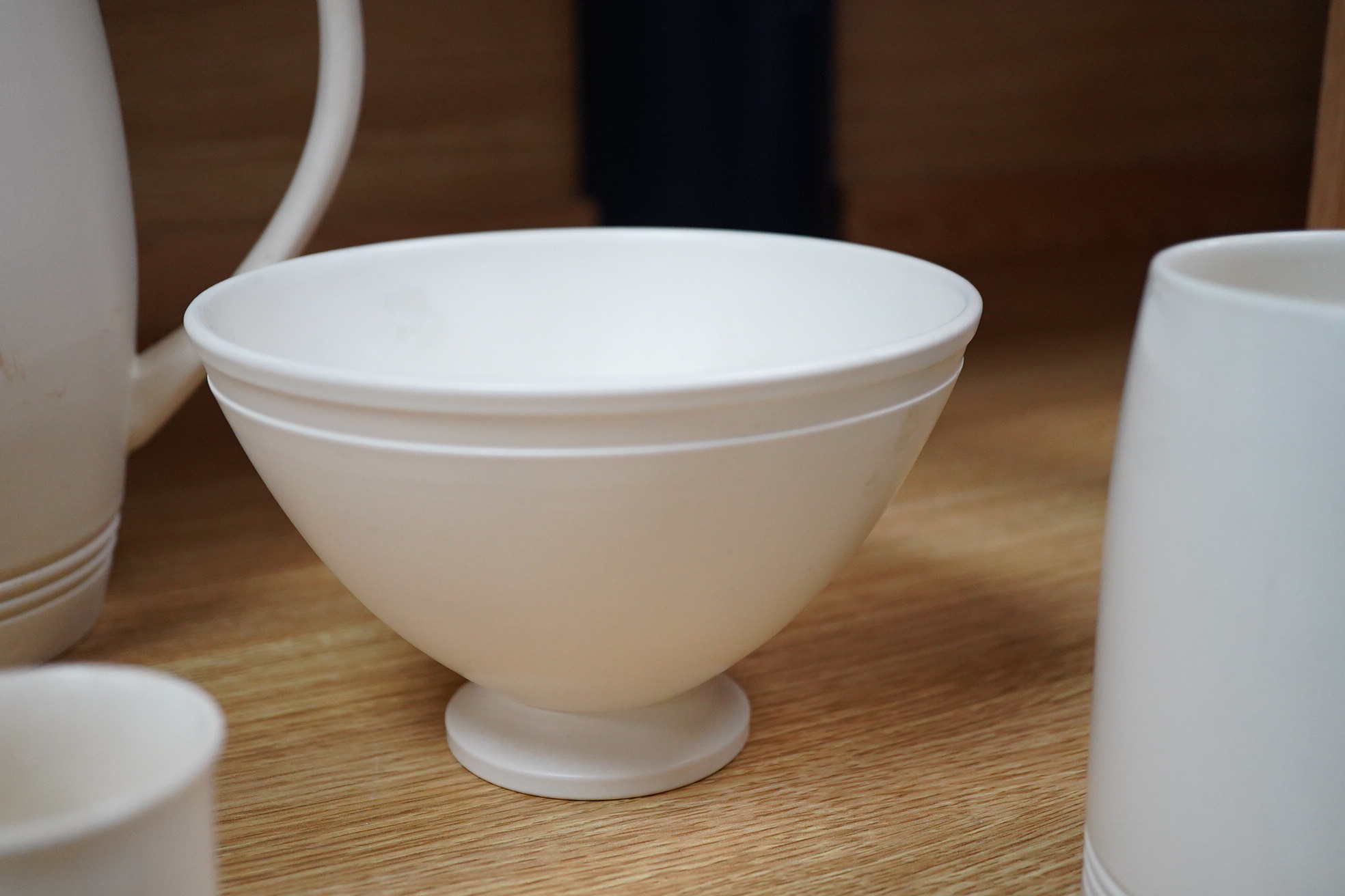 Keith Murray for Wedgwood, moonstone bowl, vase, jug, two mugs, coffee cups and small vase, largest 21cm high